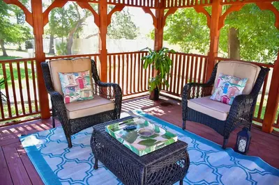 two chairs and a coffee table on a porch at Banana Leaf Villa-Marley Junior Suite in Orlando