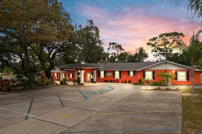 a red building with a parking lot at Banana Leaf Villa-Vintage Vibes Suites in Orlando