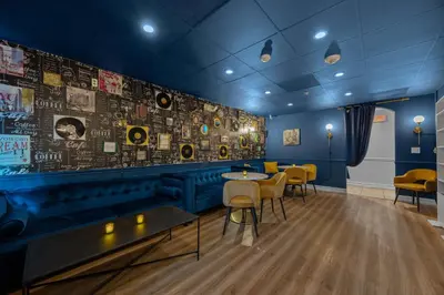 a restaurant with tables and chairs and a wall with posters at Banana Leaf Villa-Vintage Vibes Suites in Orlando