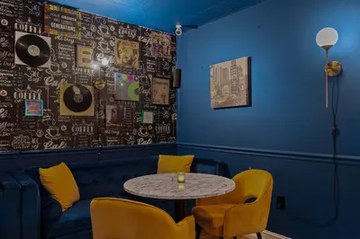 a table and chairs in a room with a blue wall at Banana Leaf Villa-Vintage Vibes Suites in Orlando