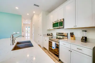 a kitchen with white cabinets and a sink at about 11 Mi to Disney Bright Kissimmee Townhome! in Orlando
