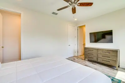 a living room with a ceiling fan and a tv at about 11 Mi to Disney Bright Kissimmee Townhome! in Orlando