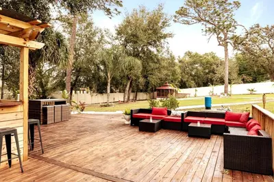 a patio with couches and tables on a wooden deck at Banana Leaf Villa-Marley Junior Suite with Living Room in Orlando