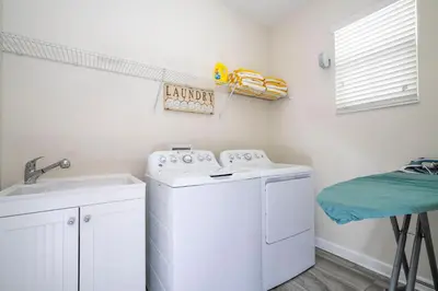 a laundry room with a washing machine and a sink at Premium 6BR home w/Pool-BBQ just 10min to Disney in Kissimmee