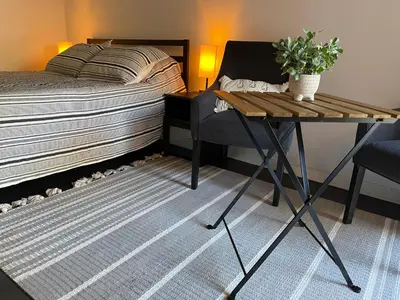 a bedroom with a bed and a table and a chair at Lovely Spacious Guesthouse in Mills 50 District in Orlando