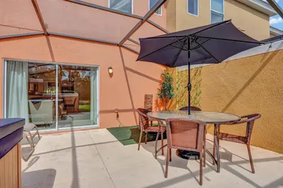 a table and chairs with an umbrella on a patio at Cozy townhouse in Encantada resort- 5 miles from Disney in Kissimmee