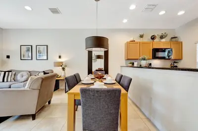 a kitchen and living room with a table and chairs at Cozy townhouse in Encantada resort- 5 miles from Disney in Kissimmee