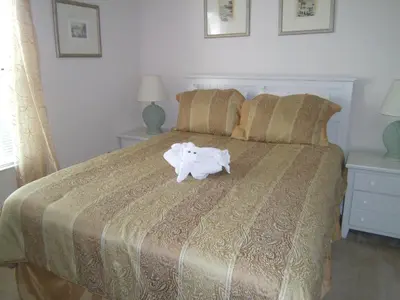 a bed with a white animal on top of it at Orlando Renters in Davenport