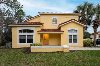 a yellow house with a lawn in front of it at Natural Reserve Home at Emerald Islands in Kissimmee