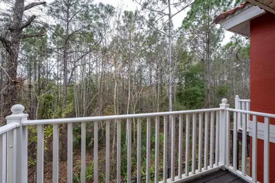 a white fence on a porch with trees in the background at Natural Reserve Home at Emerald Islands in Kissimmee