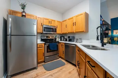 a kitchen with stainless steel appliances and wooden cabinets at Natural Reserve Home at Emerald Islands in Kissimmee