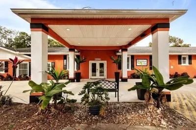 an orange building with a bench in front of it at Banana Leaf Villa-Vintage Vibes- King Suite in Orlando