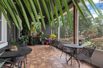 an outdoor patio with tables and chairs and trees at Banana Leaf Villa-Vintage Vibes- King Suite in Orlando