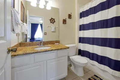 a bathroom with a sink and a toilet at 3 miles to Disney, water park, kids disney rooms, pool table, air hockey, private pool and spa in Orlando
