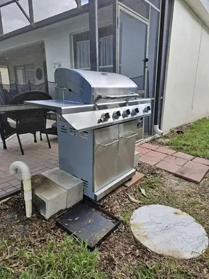 a grill sitting in the yard outside of a house at 3 miles to Disney, water park, kids disney rooms, pool table, air hockey, private pool and spa in Orlando