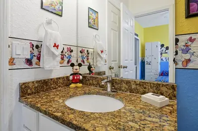 a bathroom with a sink with a stuffed animal on it at 3 miles to Disney, water park, kids disney rooms, pool table, air hockey, private pool and spa in Orlando