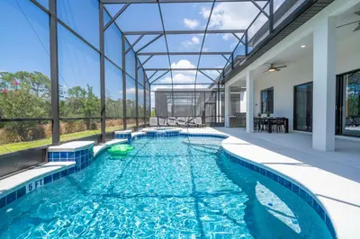a swimming pool in a house with a glass ceiling at Amazing New 15-bed home up to 30 people in Orlando