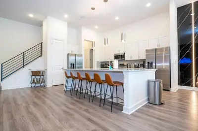 a kitchen with a bar with stools at a counter at Amazing New 15-bed home up to 30 people in Orlando