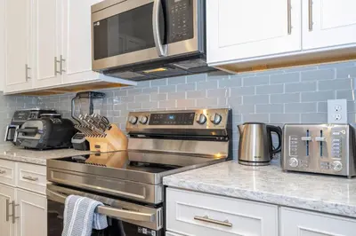 a kitchen with a stove and a microwave at Amazing New 15-bed home up to 30 people in Orlando