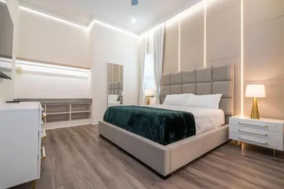 a bedroom with a large bed with a green blanket at Amazing New 15-bed home up to 30 people in Orlando