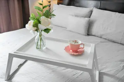 a vase of flowers and a cup of coffee on a table at 8965 Cozy home Private Pool in Kissimmee
