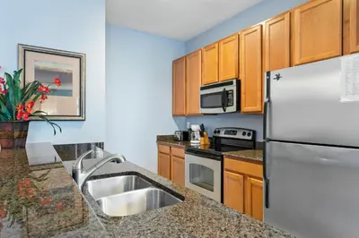 a kitchen with stainless steel appliances and wooden cabinets at 8965 Cozy home Private Pool in Kissimmee