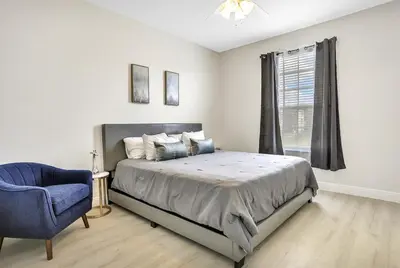 a bedroom with a bed and a blue chair at 8102-IBRAHIM · 8102 Vacation getaway at Windsor in Kissimmee