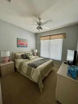 a bedroom with a bed and a ceiling fan at Lake House near Disney in Kissimmee