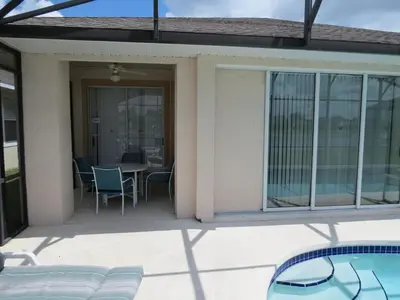 a house with a patio with a table and chairs at Lake House near Disney in Kissimmee