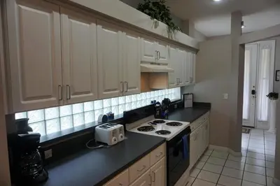 a kitchen with white cabinets and a stove top oven at Lake House near Disney in Kissimmee