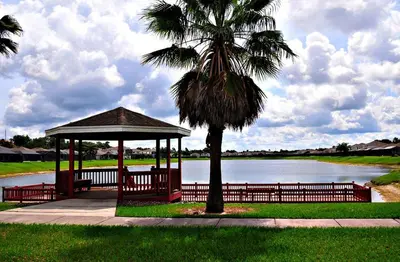 a gazebo with a palm tree next to a lake at Lake House near Disney in Kissimmee