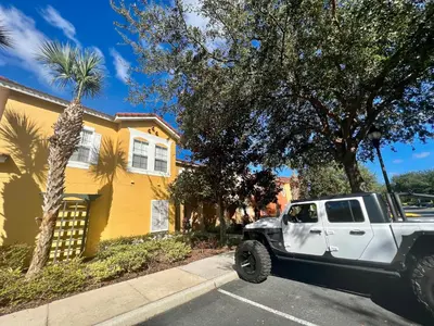 a white truck parked in front of a yellow house at Grand Deluxe 3BR Townhouse near Disney Parks in Kissimmee