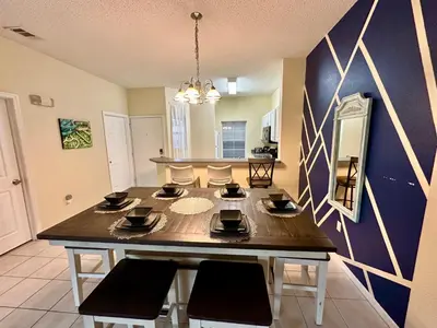 a dining room with a large wooden table and chairs at Grand Deluxe 3BR Townhouse near Disney Parks in Kissimmee