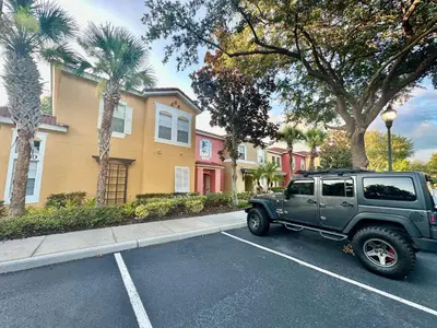 a green jeep parked in a parking lot at Grand Deluxe 3BR Townhouse near Disney Parks in Kissimmee