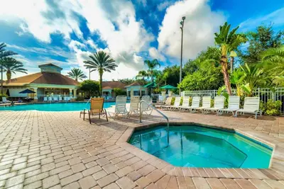 a swimming pool with chairs and a resort at Disney Fan Condo-Renovated 2024 in Kissimmee