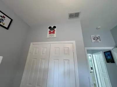 a white hallway with a white door and signs on the wall at Disney Fan Condo-Renovated 2024 in Kissimmee