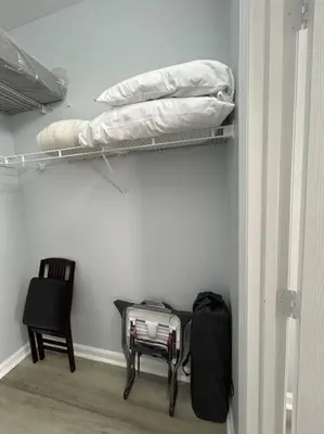 a room with a shelf with a bag and a chair at Disney Fan Condo-Renovated 2024 in Kissimmee