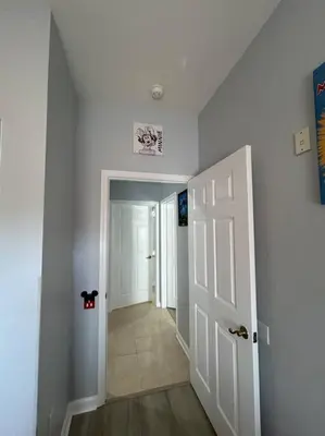 a hallway with a white door and a room with a hallway at Disney Fan Condo-Renovated 2024 in Kissimmee
