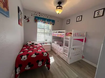 a bedroom with two bunk beds and a red blanket with cows at Disney Fan Condo-Renovated 2024 in Kissimmee