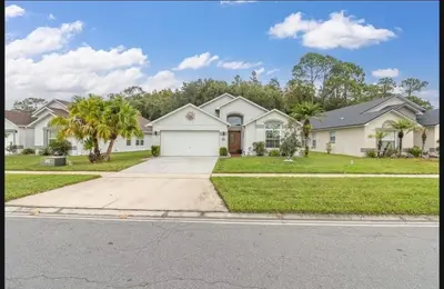 a large white house with a driveway at Tropical Escape By Shine Villas 244 in Kissimmee