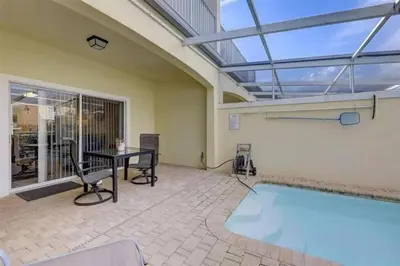a swimming pool in a room with a table and chairs at Five Vacation Homes - Orlando in Orlando