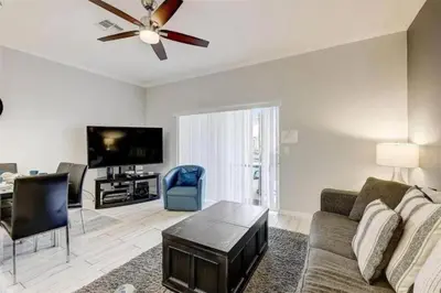 a living room with a couch and a flat screen tv at Five Vacation Homes - Orlando in Orlando