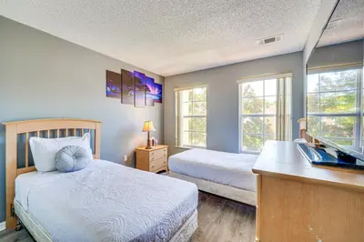 a bedroom with a bed and a desk with a laptop at 5 Mi to Disney Family-Friendly Kissimmee Retreat! in Kissimmee