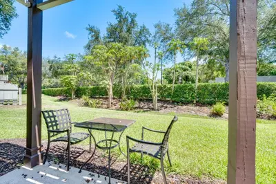 a patio with two chairs and a table in the grass at 5 Mi to Disney Family-Friendly Kissimmee Retreat! in Kissimmee