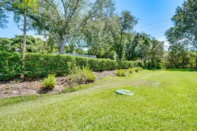a green bench in the grass in a yard at 5 Mi to Disney Family-Friendly Kissimmee Retreat! in Kissimmee