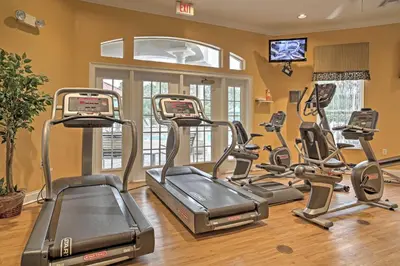 a gym with several tread machines in a room at 5 Mi to Disney Family-Friendly Kissimmee Retreat! in Kissimmee