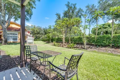 a patio with two chairs and a table in the grass at 5 Mi to Disney Family-Friendly Kissimmee Retreat! in Kissimmee