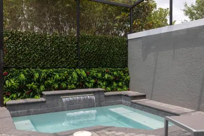 a swimming pool in the middle of a garden at Beautiful Townhome with Splash Pool near Disney 31 in Kissimmee