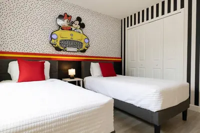 two beds in a bedroom with a car on the wall at Beautiful Townhome with Splash Pool near Disney 31 in Kissimmee