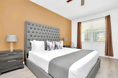 a bedroom with a large white bed and a window at Upstay-Mansion w Spa-Pool-Cinema-Games - Sleeps 36 in Kissimmee